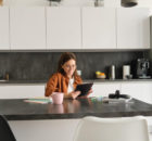 young woman in kitchen leaning on kitchen worktops